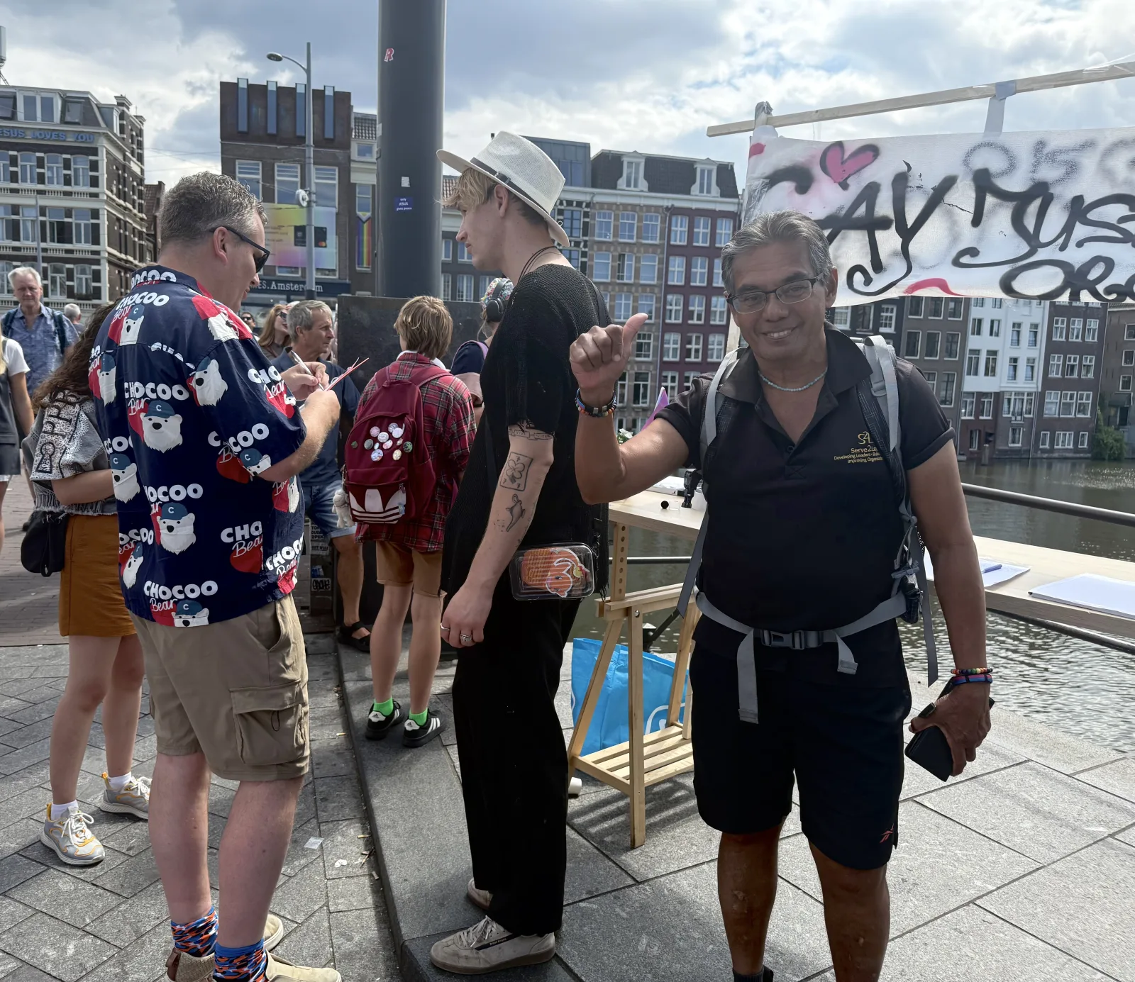 People gather around a GayJustice campaign display during WorldPride Amsterdam 2026.